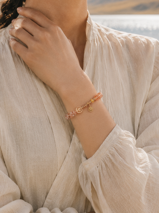 Red rutilated quartz gold bracelet lifestyle image with warm crystal tones
